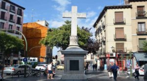 La Plaza de Puerta Cerrada con la calle de Tintoreros al fondo (pequeña calle que desemboca en la calle de Toledo) y la cruz que la caracteríza y que es una replica de la original la cual, se alzaba sobre el registro de uno de los viajes de agua de la Villa, y que fue demolida en 1873.